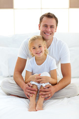 Wall Mural - Caring father with his little girl sitting on bed