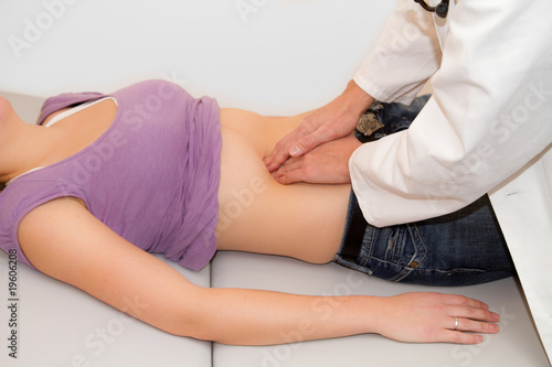 Arzt tastet Frau den Bauch ab foto de Stock.