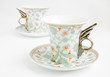 Two vintage cups with handles in form of wings, on saucers