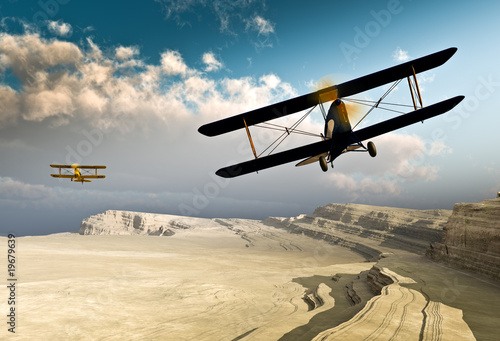 two-vintage-wwi-double-wing-biplanes-flying-over-canyon