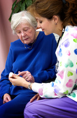 Wall Mural - Nurse giving senior woman a bottle of pills