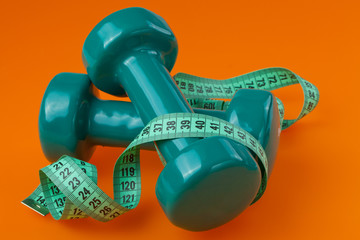 two dumbells with measuring tape