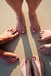 © travelview - feet of family in the fine sand of the beached in a circle