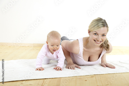 Fototapeta junge mama macht mit ihrem baby fitness + yoga uebungen
