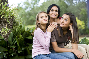 Affectionate mother and two daughters sitting together