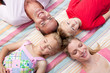© WavebreakMediaMicro - Cheerful family sleeping lying on the grass