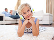 © WavebreakMediaMicro - Adorable little girl listening music lying on the floor