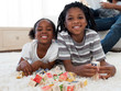© WavebreakMediaMicro - Cute brother and sister playing alphabetic cubes