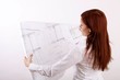 standing woman with house construction plan (focus on plan)