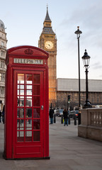 Wall Mural - a typical red phone booth in london with the big ben in the bac