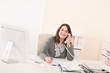 © CandyBox Images - Smiling young business woman on phone at office