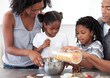 © WavebreakMediaMicro - Ethnic family making biscuits together