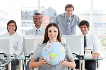 Wall Mural - Pretty businesswoman and her team showing a terrestrial globe