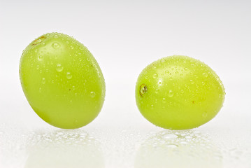 Two wet green grapes isolated on white background