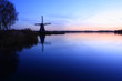 Dutch windmill at a lake during sunset