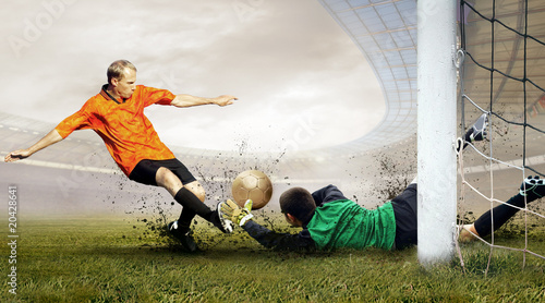 Obraz w ramie Shoot of football player and jump of goalkeeper on the field of