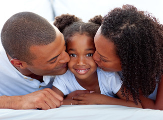 Wall Mural - Loving parents kissing their daughter