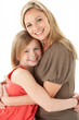 © Monkey Business - Studio Portrait Of Mother Hugging Young Daughter