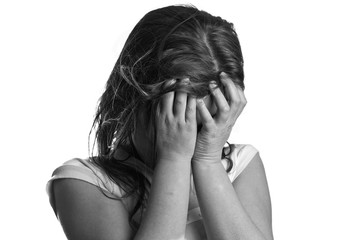 Black and white shot of a sad girl covering her face