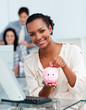 © WavebreakMediaMicro - Smiling businesswoman saving money in a piggy-bank