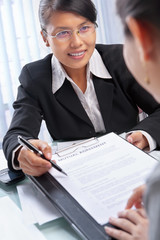 Wall Mural - Asian businesswoman explaining document to client