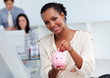 © WavebreakMediaMicro - Confident businesswoman saving money in a piggy-bank