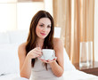 © WavebreakMediaMicro - Relaxed woman drinking coffee sitting on bed