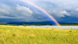 Fototapeta Tęcza - Colors rainbow over lake and fields