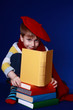 Little boy in colorful clothes reading a yellow book
