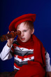 Little boy in red scarf and beret with a spyglass