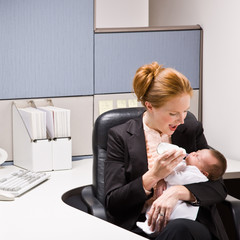 Wall Mural - Businesswoman feeding baby at desk