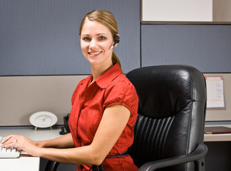 Wall Mural - Businesswoman talking on headset at desk