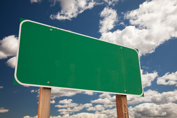 Wall Mural - Blank Green Road Sign Over Clouds