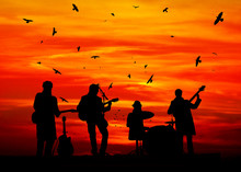 Silhouettes Of Musicians Against The Sunset