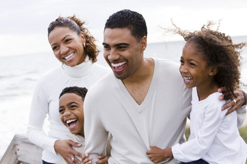 Happy African-American family with two children on beach