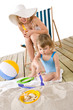 © CandyBox Images - Beach - Mother with child playing with toys in sand
