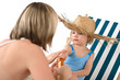 © CandyBox Images - Mother with child apply suntan lotion on beach