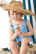 © CandyBox Images - Beach - Little girl on deck-chair with hat and ice-cream