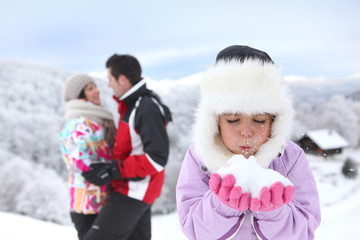  Portrait d'une fillette soufflant sur une boule de neige