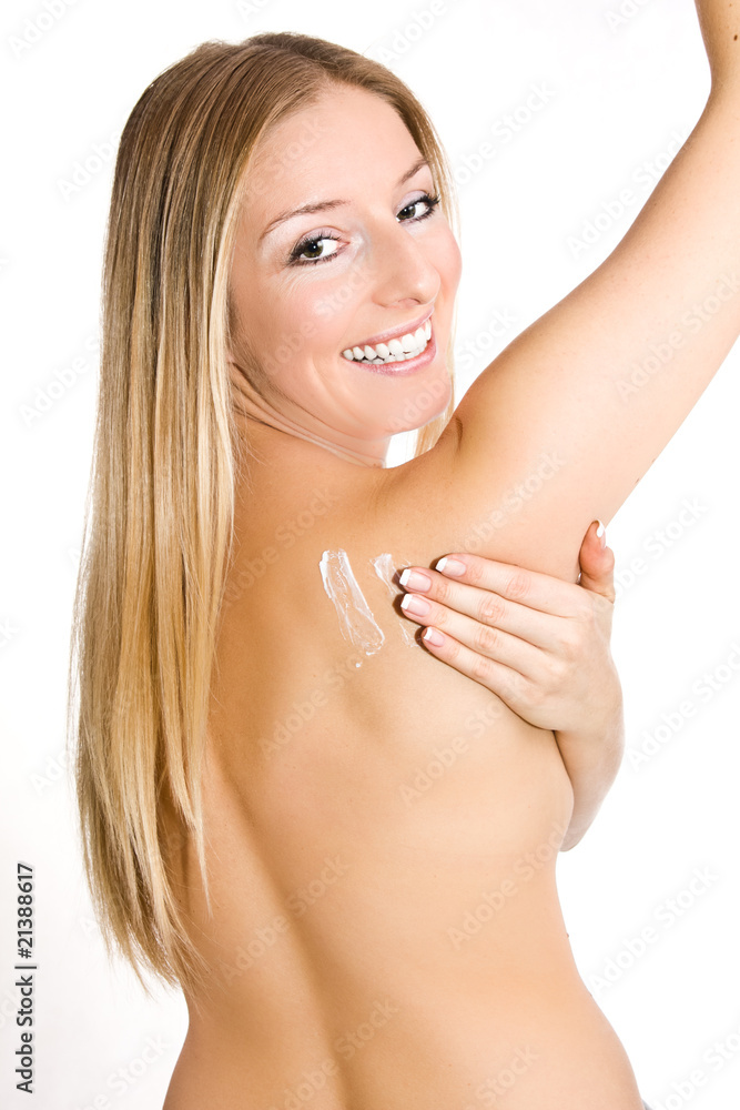 Causasian blonde woman creaming her back - obrazy, fototapety, plakaty 