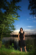 canvas print picture - junge Frau vor See mit Sonnenuntergang