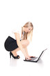 © mathom - Smiling woman sitting on the floor with laptop, formal dress