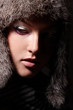 Fashion closeup portrait of young woman in fur hat