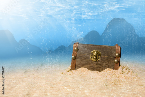 photo of treasure chest submerged underwater with light rays