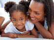 © WavebreakMediaMicro - Attentive woman and her daughter relaxing lying down on bed
