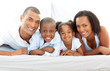 © WavebreakMediaMicro - Happy family having fun lying down on bed