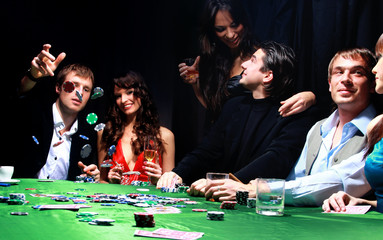 Young man throwing chips on the table while playing cards.