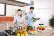 © CandyBox Images - Young happy couple cook in kitchen with cookbook