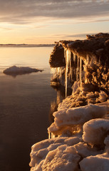 Sea on sunset with icicles