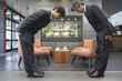 © Noel Hendrickson/Blend Images - Two businessmen bowing to each other in cafe